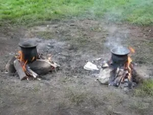 Madlavning som i Ertebølletiden. Der er godt fyret op under potterne, fordi det ellers tager lang tid inden en madskorpe dannes. Fotograferet af Bente Philippsen.